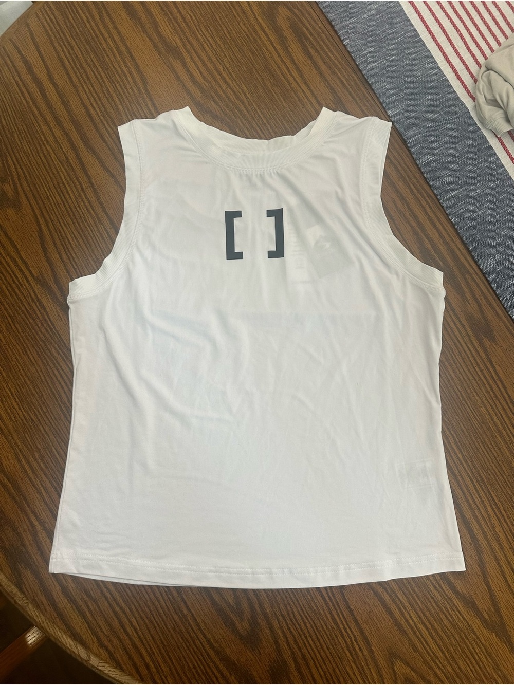 White [solidcore] sleeveless workout tank with bracket logo!